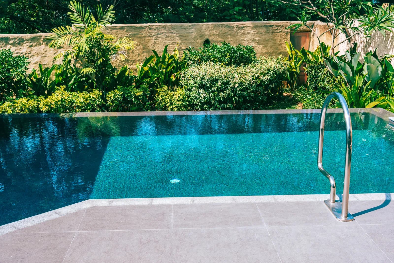 Piscine extérieure à débordement entourée de végétation — projet de déclaration préalable