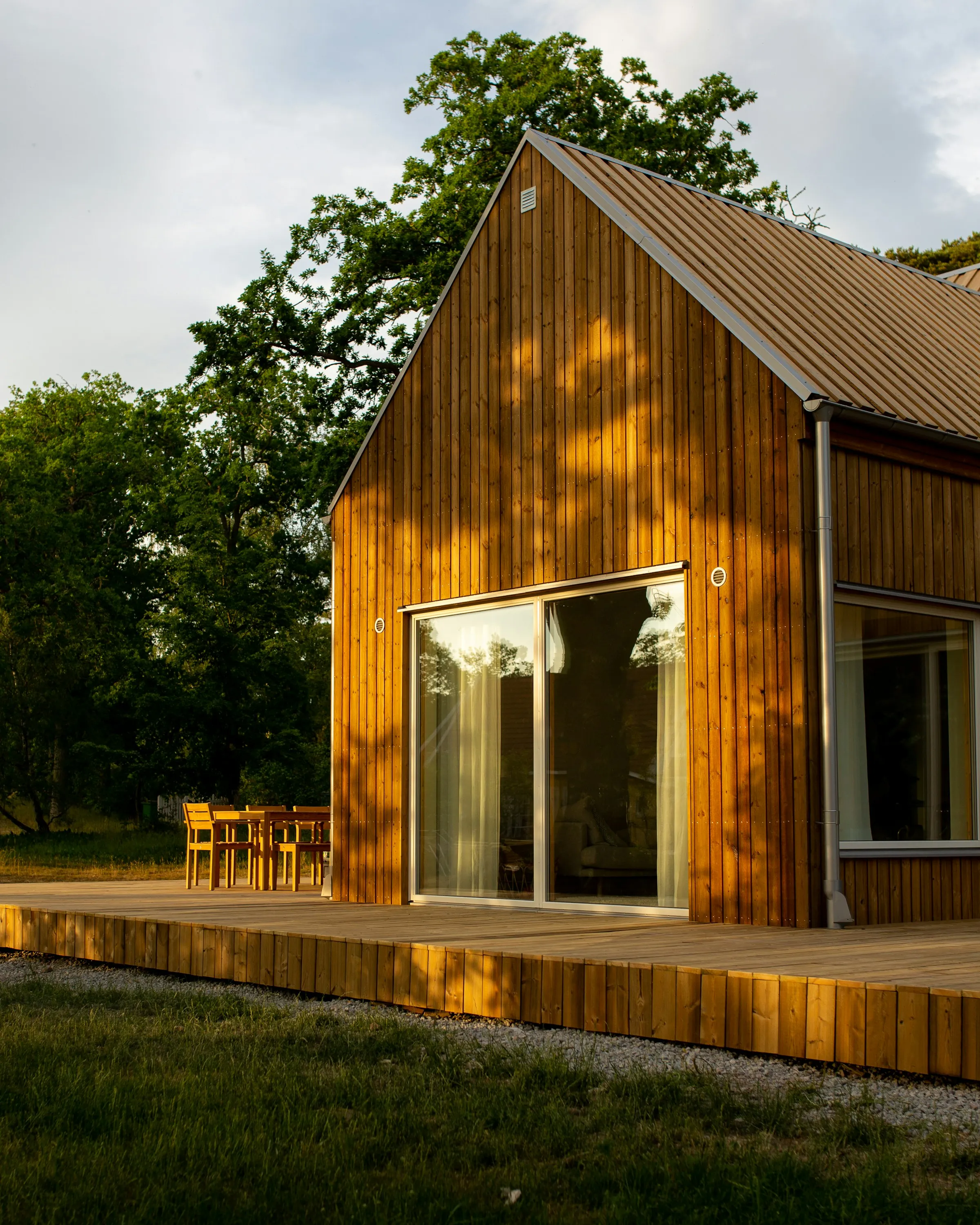 Maison bois contemporaine à toit pointu et terrasse au coucher du soleil — projet typique évalué par le simulateur Dékla